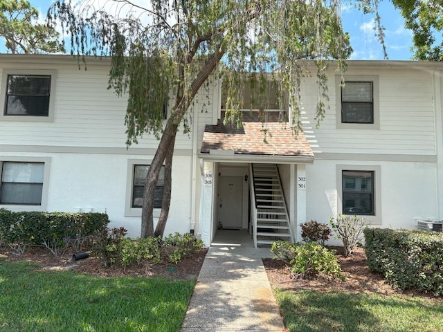 303 Meadow Ln, Oldsmar, FL 34677 - townhome / multi-family property with stairway, stucco siding, and central air condition unit
