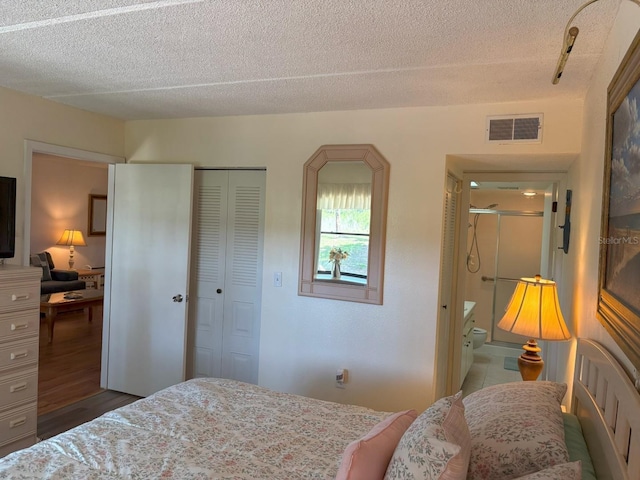 303 Meadow Ln, Oldsmar, FL 34677 - bedroom featuring a textured ceiling, a closet, wood finished floors, and connected bathroom
