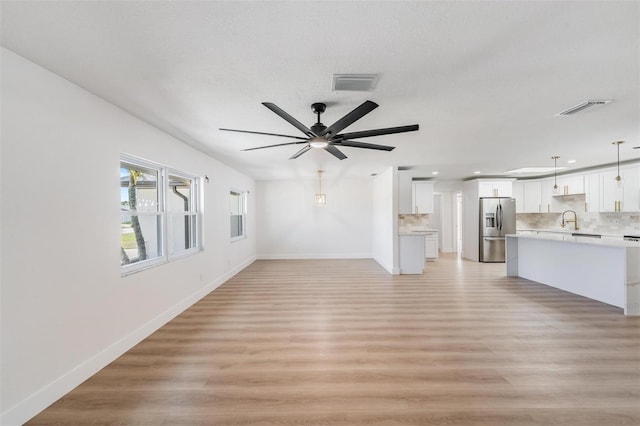 7607 22nd Ave W, Bradenton, FL 34209 - unfurnished living room with light wood finished floors, a sink, baseboards, recessed lighting, and a ceiling fan