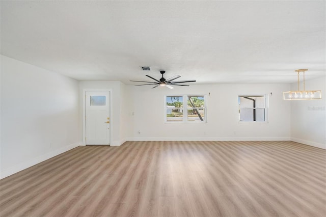 7607 22nd Ave W, Bradenton, FL 34209 - unfurnished living room with baseboards, light wood-style floors, and ceiling fan