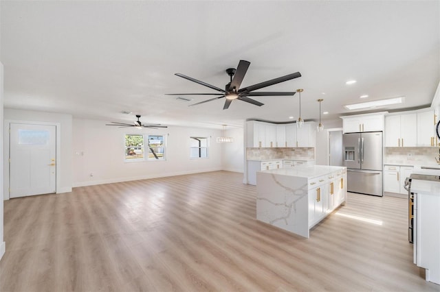 7607 22nd Ave W, Bradenton, FL 34209 - kitchen with stainless steel fridge with ice dispenser, a kitchen island, tasteful backsplash, a ceiling fan, and recessed lighting