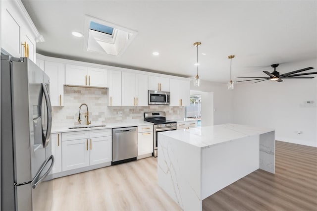7607 22nd Ave W, Bradenton, FL 34209 - kitchen with stainless steel appliances, a sink, a skylight, light wood-style flooring, and recessed lighting