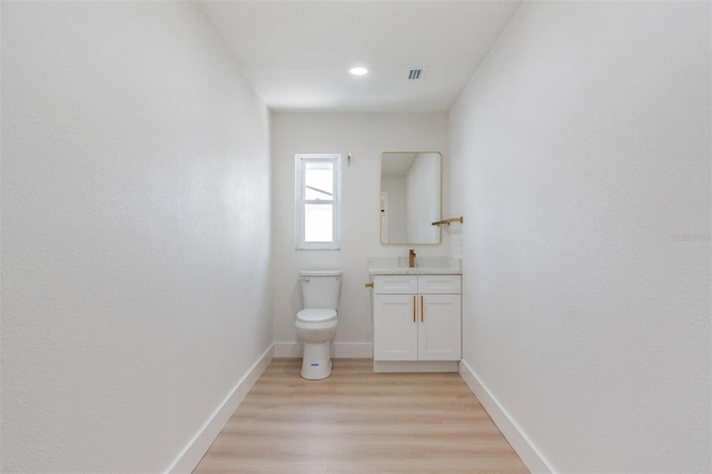 7607 22nd Ave W, Bradenton, FL 34209 - bathroom with vanity, toilet, wood finished floors, and baseboards