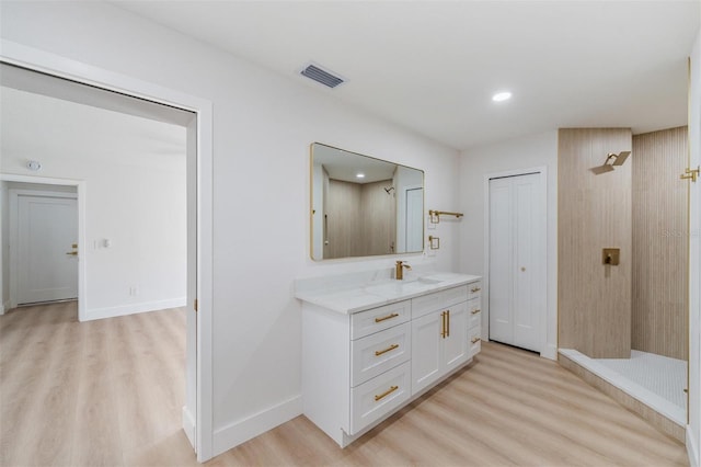 7607 22nd Ave W, Bradenton, FL 34209 - full bath featuring wood finished floors, tiled shower, vanity, baseboards, and recessed lighting