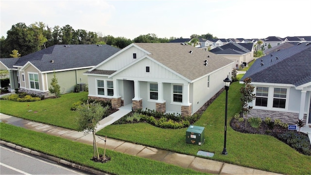 28547 Hillcrest Valley Blvd, Wesley Chapel, FL 33543 - view of front of home with stone siding, board and batten siding, a front lawn, and a shingled roof