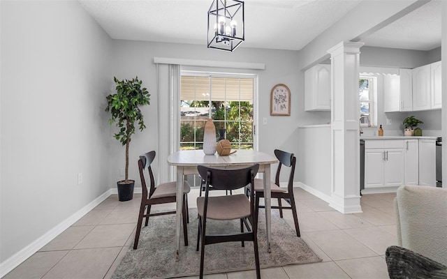 2613 E 113th Ave, Tampa, FL 33612 - dining space featuring light tile patterned flooring, healthy amount of natural light, a textured ceiling, decorative columns, and baseboards