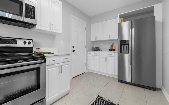 2613 E 113th Ave, Tampa, FL 33612 - kitchen featuring stainless steel appliances, light countertops, white cabinets, and light tile patterned flooring