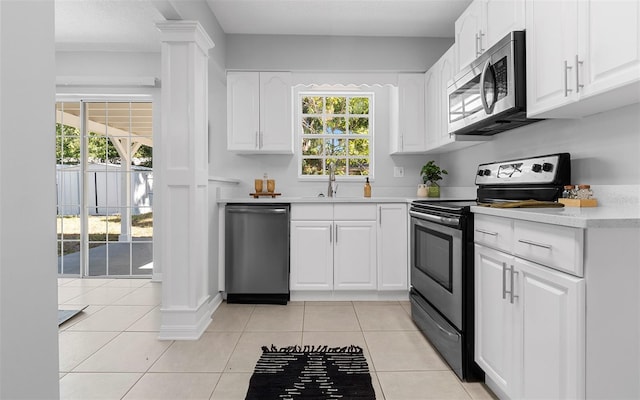2613 E 113th Ave, Tampa, FL 33612 - kitchen featuring appliances with stainless steel finishes, a sink, light countertops, and white cabinetry