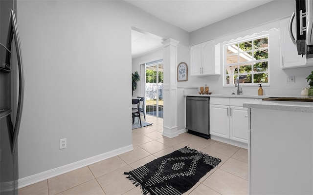 2613 E 113th Ave, Tampa, FL 33612 - kitchen with appliances with stainless steel finishes, a sink, white cabinets, light tile patterned floors, and baseboards