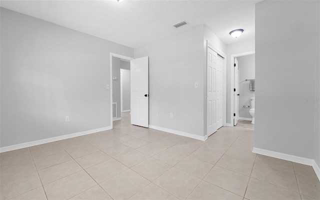 2613 E 113th Ave, Tampa, FL 33612 - spare room featuring light tile patterned floors, baseboards, and a textured ceiling