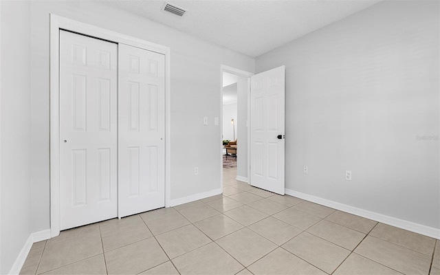 2613 E 113th Ave, Tampa, FL 33612 - unfurnished bedroom with light tile patterned floors, a closet, and baseboards