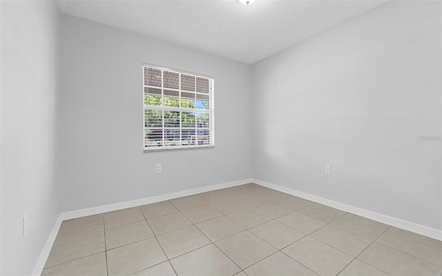 2613 E 113th Ave, Tampa, FL 33612 - unfurnished room with light tile patterned flooring, baseboards, and a textured ceiling