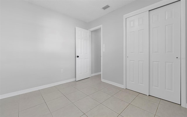 2613 E 113th Ave, Tampa, FL 33612 - unfurnished bedroom with light tile patterned floors, a closet, and baseboards