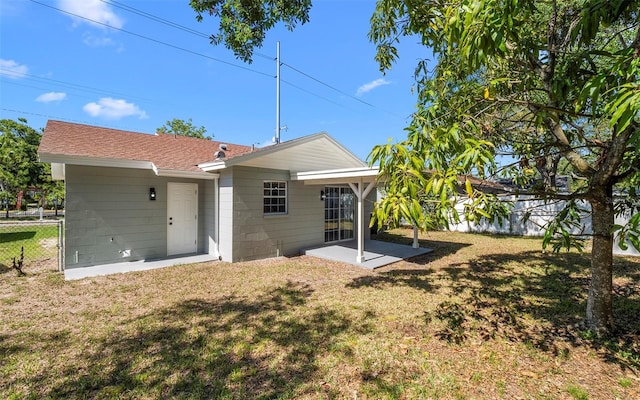 2613 E 113th Ave, Tampa, FL 33612 - rear view of house with concrete block siding, a patio, and roof with shingles