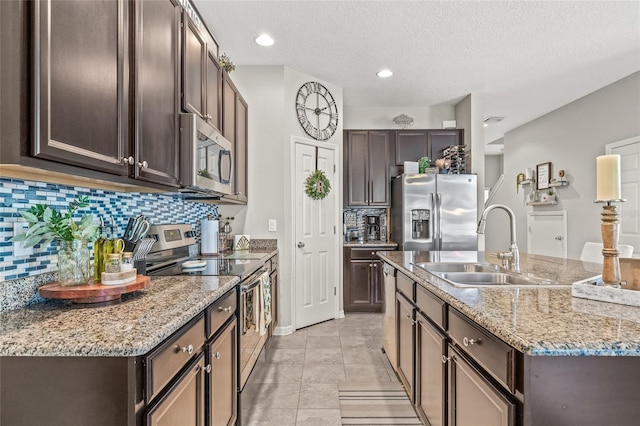6974 Holly Heath Dr, Riverview, FL 33578 - kitchen featuring appliances with stainless steel finishes, a sink, dark brown cabinetry, a textured ceiling, and recessed lighting