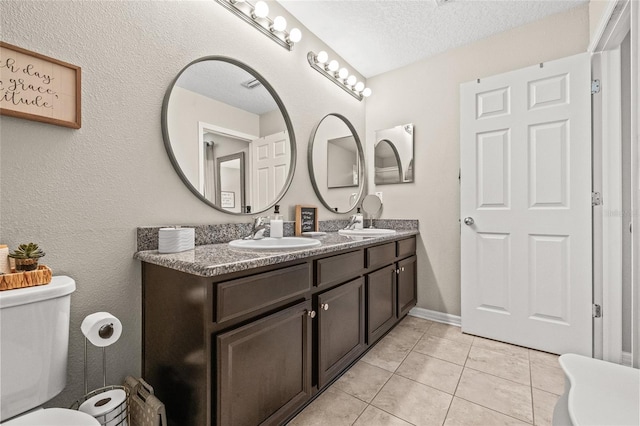 6974 Holly Heath Dr, Riverview, FL 33578 - full bathroom featuring a textured ceiling, toilet, tile patterned floors, and double vanity