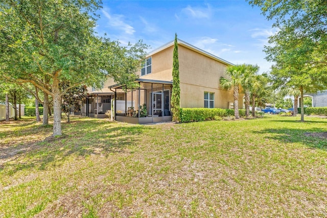6974 Holly Heath Dr, Riverview, FL 33578 - rear view of house featuring a sunroom, stucco siding, and a lawn