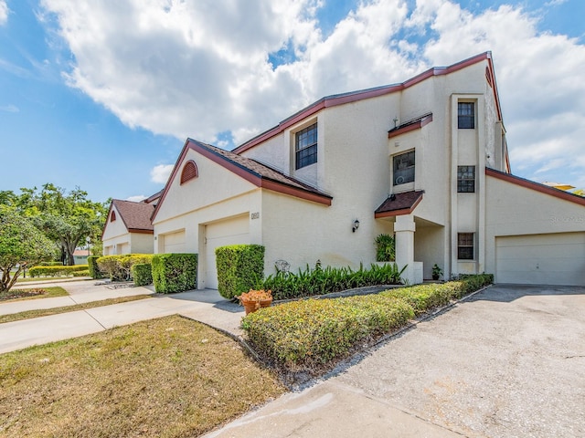 3455 Countryside Blvd Unit 101, Clearwater, FL 33761 - view of front facade with asphalt driveway, an attached garage, and stucco siding