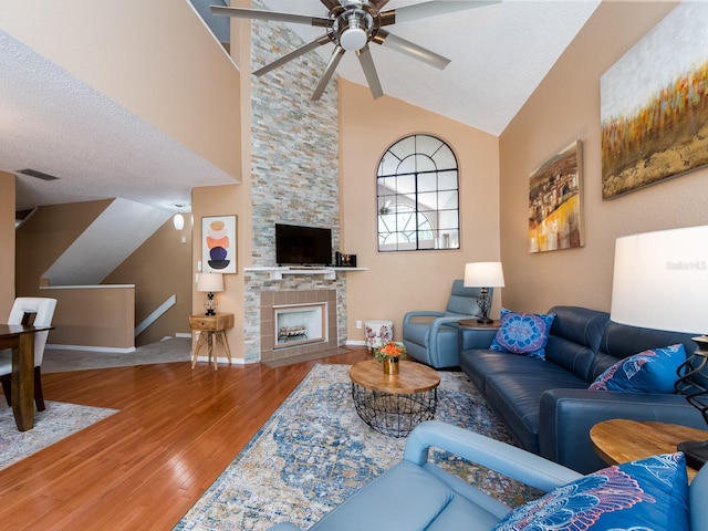 3455 Countryside Blvd Unit 101, Clearwater, FL 33761 - living area featuring a ceiling fan, wood finished floors, high vaulted ceiling, baseboards, and a stone fireplace