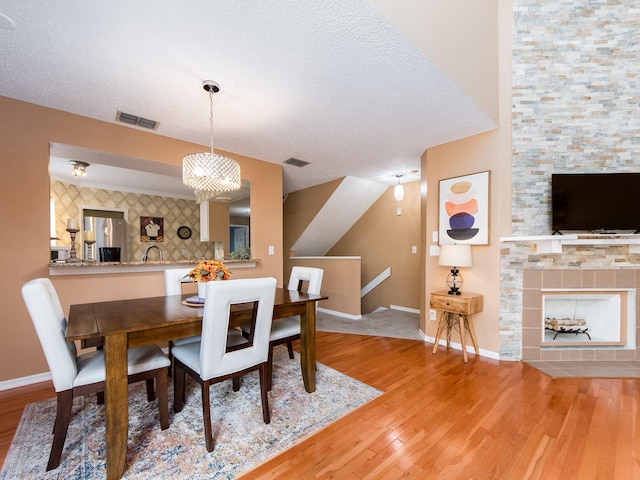 3455 Countryside Blvd Unit 101, Clearwater, FL 33761 - dining area with wood finished floors, baseboards, a tiled fireplace, and a textured ceiling