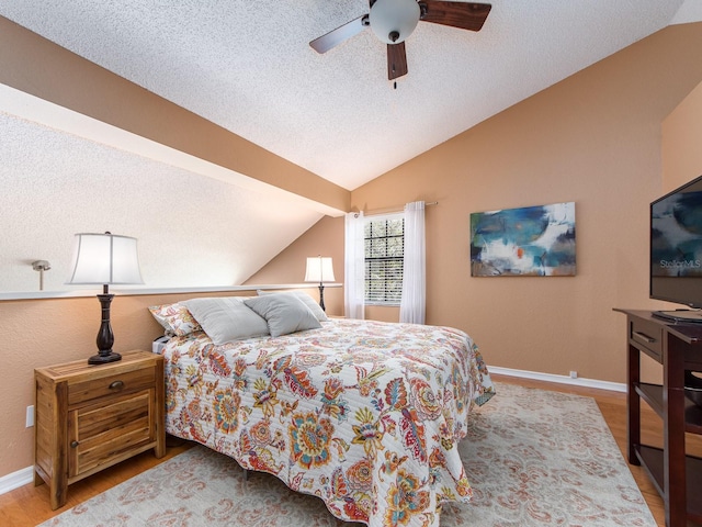 3455 Countryside Blvd Unit 101, Clearwater, FL 33761 - bedroom with vaulted ceiling, a textured ceiling, wood finished floors, baseboards, and a ceiling fan