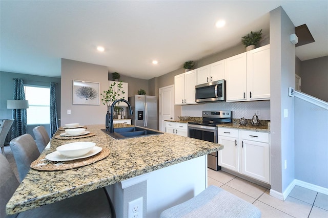 10826 Trailing Vine Dr, Tampa, FL 33610 - kitchen with stainless steel appliances, a sink, white cabinets, light tile patterned floors, and recessed lighting