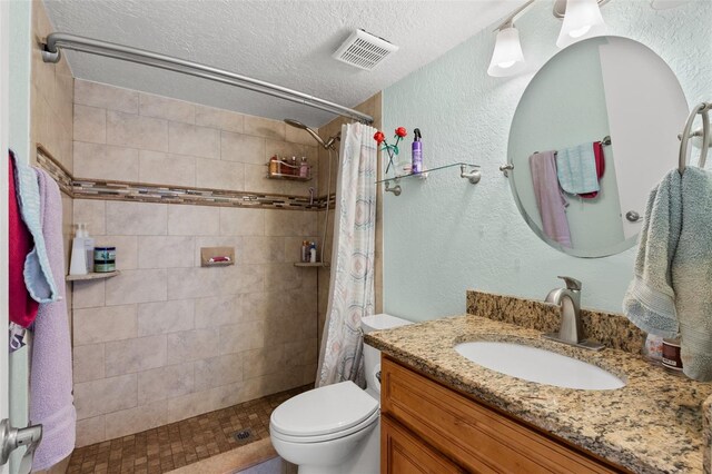 4032 Cortez Dr Unit A, Tampa, FL 33614 - bathroom featuring vanity, toilet, tiled shower, a textured ceiling, and a textured wall