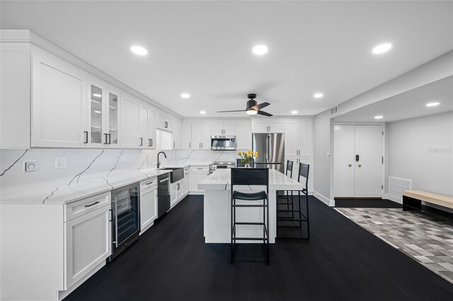 100 Oakmont Ln Unit 802, Belleair, FL 33756 - kitchen with wine cooler, stainless steel appliances, light stone counters, a kitchen bar, and recessed lighting
