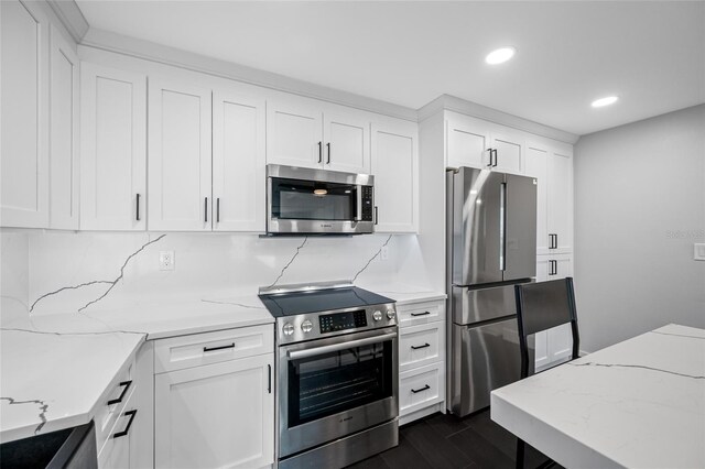 100 Oakmont Ln Unit 802, Belleair, FL 33756 - kitchen with appliances with stainless steel finishes, recessed lighting, white cabinets, decorative backsplash, and light stone countertops