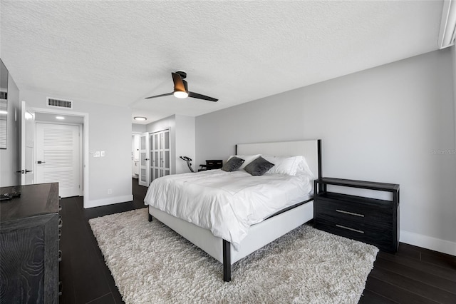 100 Oakmont Ln Unit 802, Belleair, FL 33756 - bedroom with baseboards, dark wood-style floors, ceiling fan, a textured ceiling, and french doors