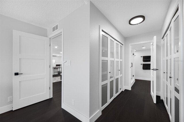 100 Oakmont Ln Unit 802, Belleair, FL 33756 - corridor with baseboards, dark wood finished floors, and a textured ceiling