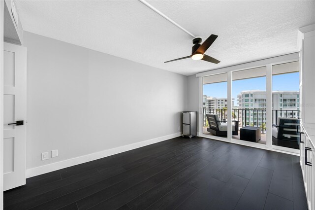100 Oakmont Ln Unit 802, Belleair, FL 33756 - spare room with ceiling fan, dark wood finished floors, baseboards, a textured ceiling, and floor to ceiling windows