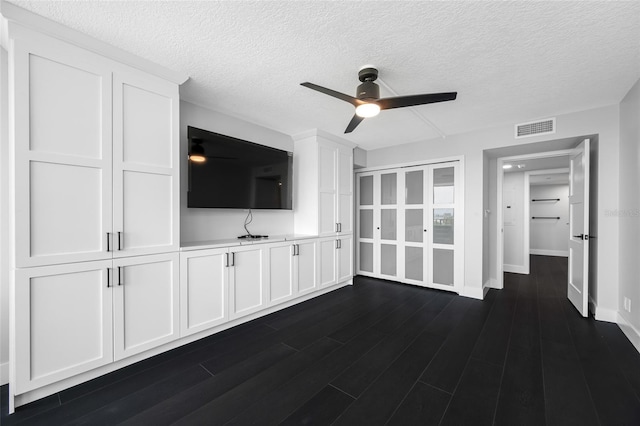 100 Oakmont Ln Unit 802, Belleair, FL 33756 - unfurnished living room featuring a ceiling fan, baseboards, a textured ceiling, and dark wood-style flooring