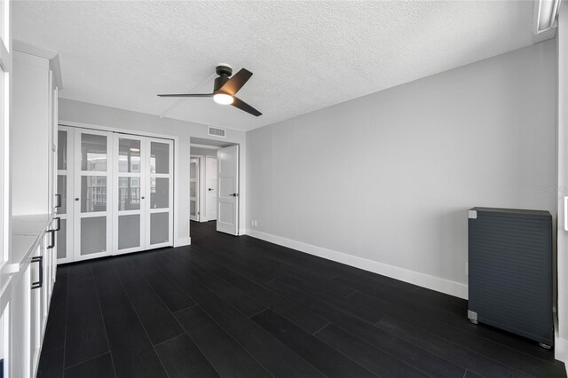100 Oakmont Ln Unit 802, Belleair, FL 33756 - empty room with a ceiling fan, baseboards, dark wood finished floors, and a textured ceiling
