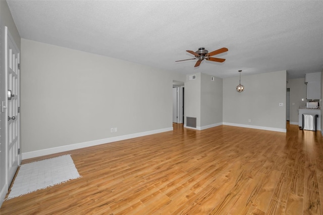 2073 Denmark St Unit 9, Clearwater, FL 33763 - unfurnished living room with ceiling fan, light wood-style flooring, baseboards, and a textured ceiling