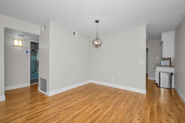 2073 Denmark St Unit 9, Clearwater, FL 33763 - unfurnished dining area featuring light wood-style floors, a chandelier, and baseboards