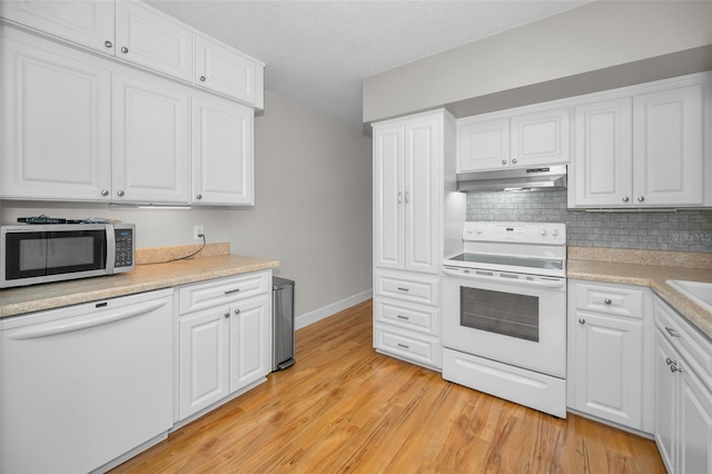 2073 Denmark St Unit 9, Clearwater, FL 33763 - kitchen featuring white appliances, under cabinet range hood, light wood-style floors, and white cabinets