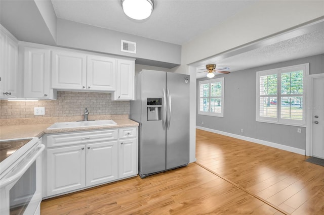 2073 Denmark St Unit 9, Clearwater, FL 33763 - kitchen with stainless steel fridge, a sink, a ceiling fan, light countertops, and white cabinetry