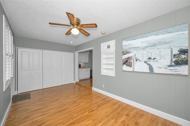 2073 Denmark St Unit 9, Clearwater, FL 33763 - unfurnished bedroom with light wood-style floors, baseboards, a textured ceiling, a closet, and a ceiling fan