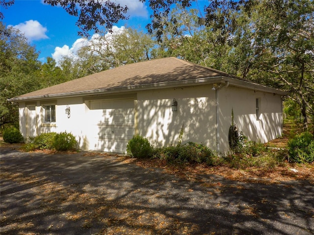 12271 Centralia Rd, Weeki Wachee, FL 34614 - view of home's exterior with driveway, roof with shingles, and stucco siding