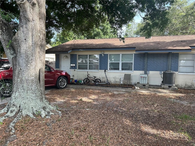 560 73rd Ave N, Saint Petersburg, FL 33702 - view of front of house featuring cooling unit, concrete block siding, and a shingled roof