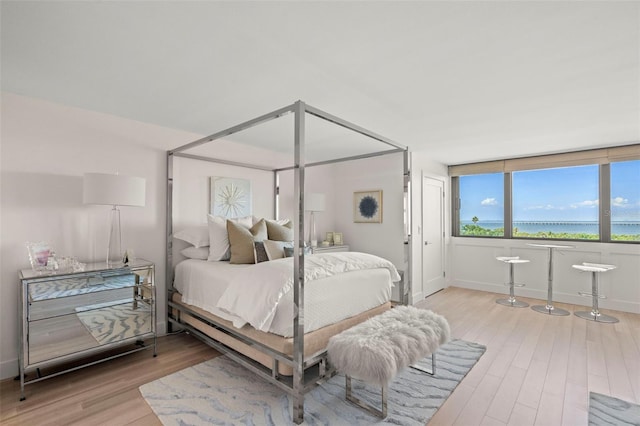 2620 Cove Cay Dr Unit 704, Clearwater, FL 33760 - bedroom featuring wood finished floors, baseboards, and a water view