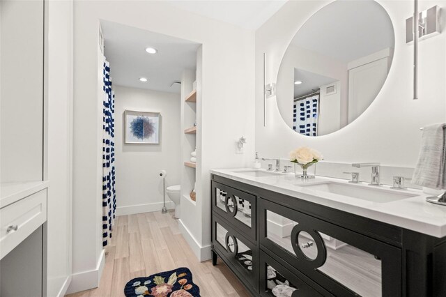 2620 Cove Cay Dr Unit 704, Clearwater, FL 33760 - full bathroom with double vanity, wood finished floors, toilet, baseboards, and recessed lighting