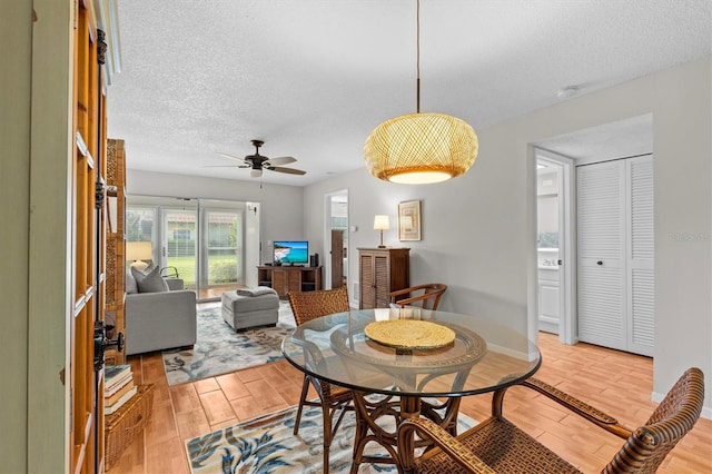 1701 Pinehurst Rd Unit 9G, Dunedin, FL 34698 - dining area featuring light wood-style floors, a ceiling fan, and a textured ceiling