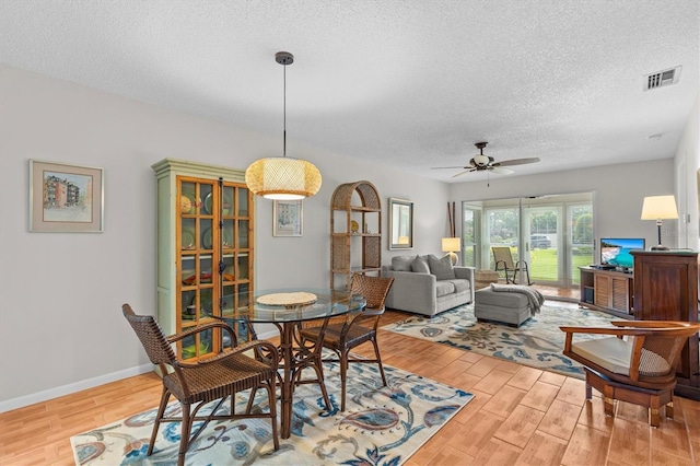 1701 Pinehurst Rd Unit 9G, Dunedin, FL 34698 - dining area featuring a textured ceiling, wood finished floors, ceiling fan, and baseboards