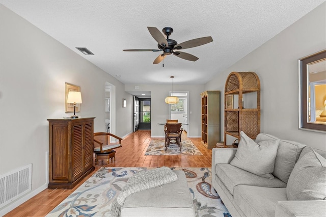 1701 Pinehurst Rd Unit 9G, Dunedin, FL 34698 - living area featuring light wood finished floors, ceiling fan, baseboards, and a textured ceiling