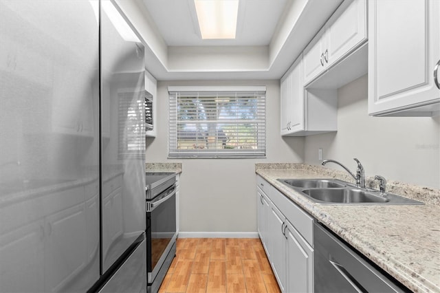 1701 Pinehurst Rd Unit 9G, Dunedin, FL 34698 - kitchen featuring a sink, appliances with stainless steel finishes, light wood-type flooring, white cabinets, and light countertops
