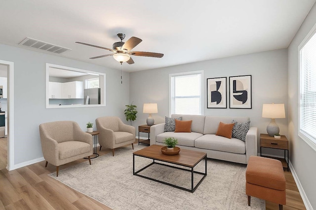 2406 E Clark St, Tampa, FL 33605 - living room featuring light wood-type flooring, a ceiling fan, and baseboards