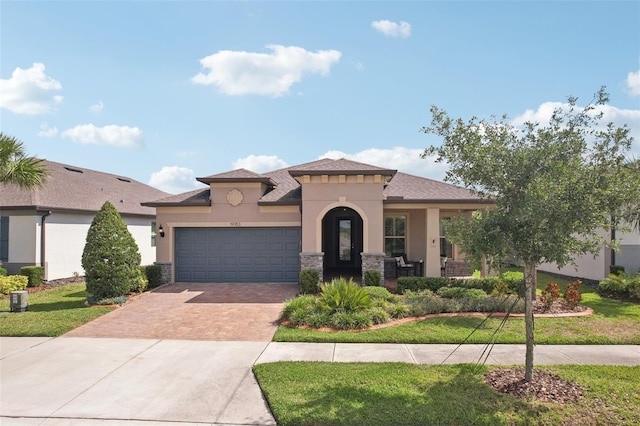 19183 Coastal Shore Ter, Land O Lakes, FL 34638 - mediterranean / spanish home featuring decorative driveway, stucco siding, an attached garage, and a front lawn