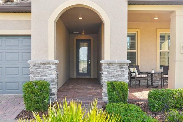 19183 Coastal Shore Ter, Land O Lakes, FL 34638 - doorway to property featuring stucco siding, a garage, and stone siding